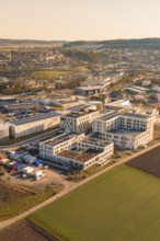 Panoramic view of an urban environment, modern buildings and surrounding fields in morning light,