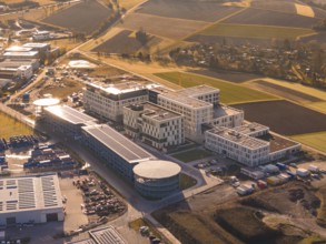 Spacious modern building complexes on the outskirts of a city surrounded by fields, new hospital on