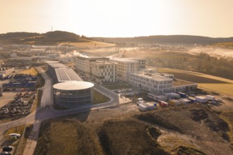 New industrial area with modern buildings and fields in the background at sunrise, new hospital at