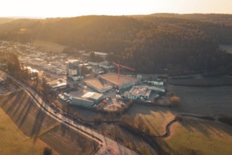Landscape scene at sunset with road, urban area and hills in the background, Neubau Rewe,