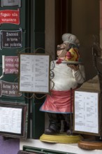 Cooking figure with fish in front of a restaurant, Burano, Veneto, Italy