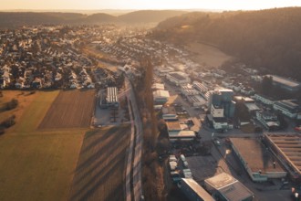 Commercial and residential areas blending with fields and hills under sunset glow, Aidlingen,