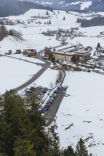 Snowy village with parking lots and picturesque mountains viewed from afar, specialist clinic for