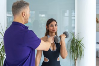 Physiotherapist male trainer assisting a young woman client with rehabilitation and strength
