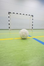 A handball is on a yellow stripe in front of a goal in a hall, Handball, Calw, Germany