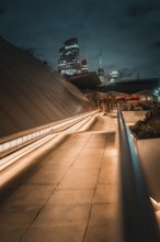 Illuminated modern architecture path leading to London skyline at night, London, United Kingdom