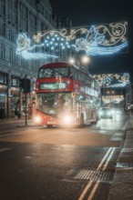 Red double-decker bus travels through London at night under Christmas lights, London, Great Britain