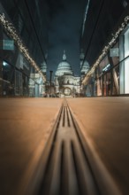Central view of cathedral at night through symmetrical modern facades, London, United Kingdom