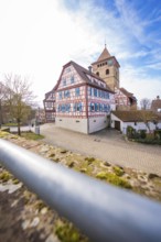 View of half-timbered houses and church tower with cobblestones and blue sky, Ötisheim, Enzkreis,