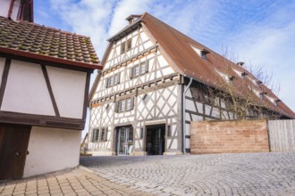Timbered house with tiled roof and cobblestone road under blue sky, Ötisheim, Enzkreis, Germany
