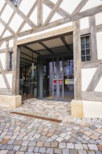 Entrance of a charming half-timbered house with glass front and cobblestones in traditional