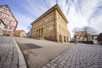Impressive sandstone building on a quiet paved road under a cloudy sky, Ötisheim, Enzkreis, Germany