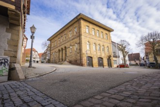 Historic building and wide cobblestone street with lanterns under blue sky, Ötisheim, Enzkreis,