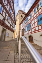 Narrow alley with half-timbered houses and view of church tower, traditional atmosphere, Ötisheim,
