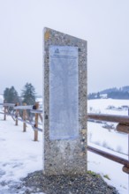 Stone monument with text board on a snowy path in winter, Sinnraum, Oberreute, Allgäu, Bavaria,