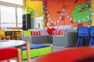 Child-friendly seating area with cuddly toys and colorful pillows, decorative elements in the