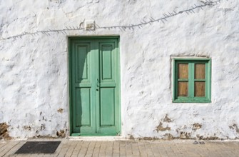 Typical white house with turquoise wooden door and window in an alley, Teguise, Lanzarote, Canary