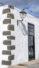 Typical white house with wooden door and alleyway lamp in an alley, Teguise, Lanzarote, Canary