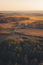 Fields and farm surrounded by forests at dusk, warm colors create a peaceful atmosphere, Gechingen,
