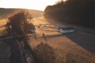 Sewage treatment plant in a meadow surrounded by trees at sunset, rural and peaceful atmosphere,