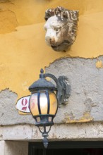 Sculpture of a lion's head and lantern above an entrance, Venice, Veneto, Italy