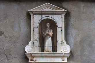 Sculpture of a priest in a niche at a residential building, Venice, Veneto, Italy