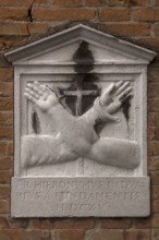 Memorial plaque with crossed hands on a house wall, Venice, Veneto, Italy