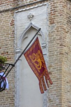Waving Venetian flag on a balcony, Venice, Veneto, Italy
