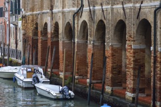Arcade with brick columns on the canal, Venice, Veneto, Italy