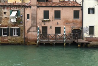 Old houses on the canal with boat dock, Venice, Veneto, Italy