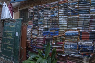 Stacked books on a wall after flood damage in a bookstore, Venice, Veneto, Italy