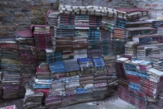 Stacked books on an outdoor wall after flood damage in a bookstore, Venice, Veneto, Italy