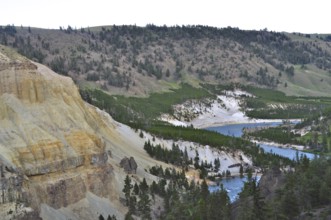 Wide landscape with a river snaking through wooded hills and steep cliffs, Yellowstone National