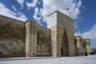 Historic stone architecture with massive gate and towers under a sunny sky, portal of the