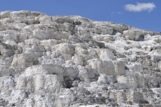 White, layered volcanic deposits under blue sky, Yellowstone National Park, Wyoming, USA
