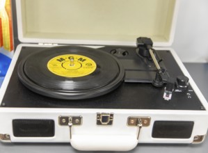 Vintage portable record player with 45 RPM vinyl record on turntable with MGM label