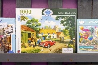 Boxed jigsaw puzzles on display in secondhand charity shop, UK