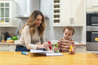 Mother and son coloring together at the kitchen table, sharing a joyful, candid moment of