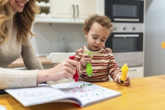 Young child and mother engaging in a fun creative painting activity, using colorful paint dot