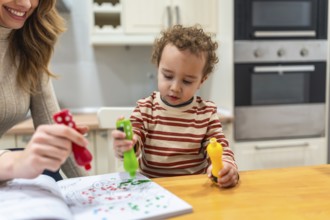 Mother and young child engaging in fun coloring activities at a kitchen island, using colorful dot