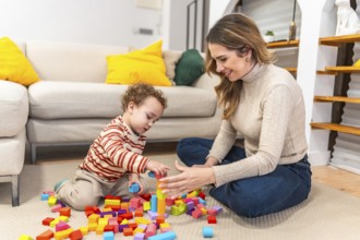 Young mother smiling, sitting on the floor with her toddler, actively engaging in playtime and