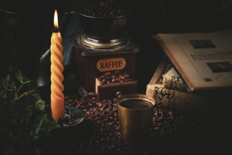 Cosy scene with old coffee grinder, steaming coffee and burning candle in a dark atmosphere