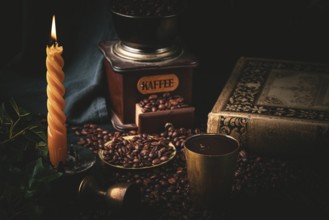Atmospheric dark scene with coffee, old coffee grinder and a burning candle
