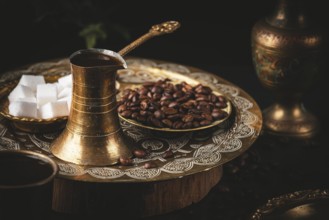 Oriental coffee scene with golden pot and sugar cubes served on a decorated tray