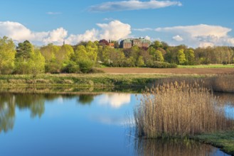 View of a small lake at Burgscheidungen Castle in evening light in spring, Unstrut Valley,