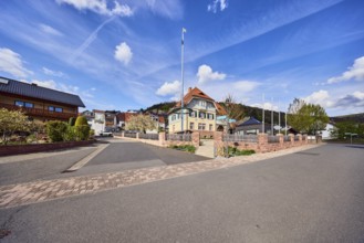 Town hall, maypole, flagpoles, roads, commercial buildings, residential buildings, single-family