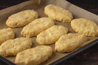 Unbaked potato rolls on a baking tray lined with baking paper
