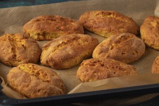 Freshly baked potato rolls on a baking tray lined with baking paper