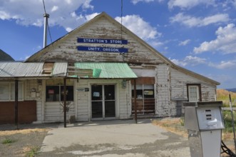 Close-up of a white wooden building, Stratton's Store, with signs and weathered paint, Unity,
