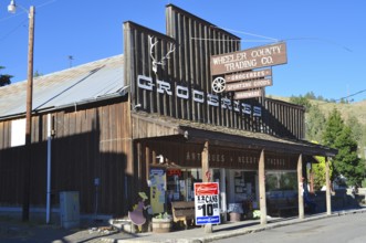 A shop with a wooden façade and several signs identifying the shop as a retail space, Mitchell,